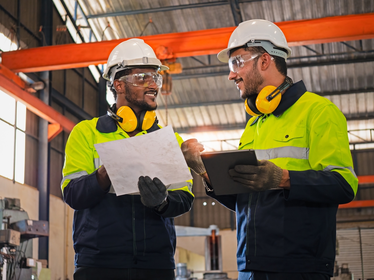 Two,Factory,Engineers,Wearing,Hard,Helmets,,Uniforms,,And,Safety,Glasses